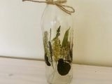Glass bottle with real leaves and grasses
